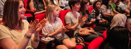 Students clapping in an auditorium