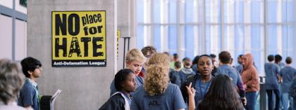 Students standing in hallway next to no place for hate sign