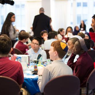 Students and teachers around tables