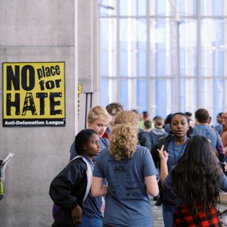 Students standing in hallway next to no place for hate sign