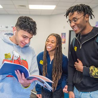 Students looking at No Place For Hate Guide in a classroom