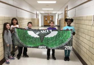 Students holding a banner in the hallway