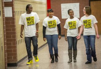 Students walking down hallway chatting 