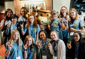 Students gathered around smiling with mascot